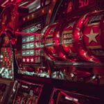 A close-up view of fruit machine slot reels with bright lights in a casino environment.